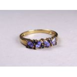 A 9ct yellow gold ring - set with sapphire and tanzanite, size V/W, weight 2.8g.