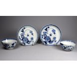 A pair of mid 18th century English blue and white tea bowls and saucers - with foliate decoration,