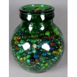 A glass carboy containing a large quantity of marbles - height 30cm.