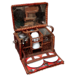 An early 20th century wicker picnic hamper for two - including a spirit kettle, cups, saucers and