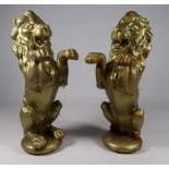 A pair of cast iron, gilt painted lions - raised on hind legs, height 30cm.