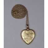 A 9ct yellow gold heart shaped locket - engraved with foliage on a fine 9ct yellow gold chain, total