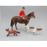 A Beswick huntsman - mounted and wearing a red jacket, height 20cm, together with two hounds and a