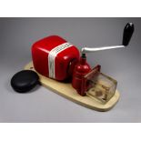 A vintage Kym & Kym wall mounted coffee grinder - with a red ceramic bean hopper and clear glass