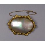 An early 20th century yellow metal oval brooch - set with mother of pearl, width 6cm.