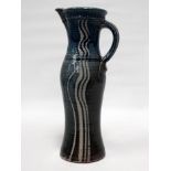 A 20th century pottery jug - with blue glaze, of slender baluster form, impressed mark to base,