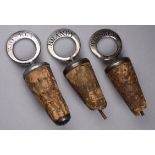 Three white metal and cork bottle stoppers - two for Whiskey, one for Brandy.