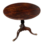 A George III oak tripod table - the circular tilt top above a baluster support and cabriole legs