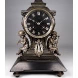 A late 19th century spelter mantel clock - of square baluster form and flanked by cherubs, the black