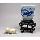 A late 19th century Chinese blue and white cup - decorated with landscape scenes, height 8cm, on a