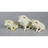 A 20th century Belleek pig - white glazed in a seated pose, height 7cm, together with two further