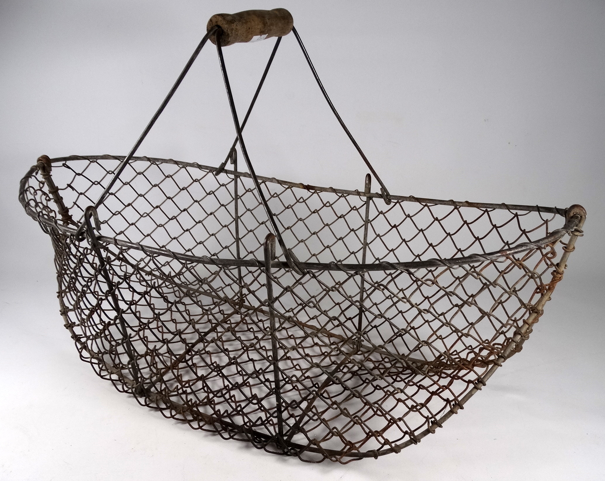 An early 20th century galvanised wire egg basket - of boat form with a turned wooden handle, width