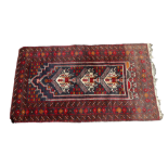 An Afghan Balouch rug - the madder ground with a central medallion with interlocked geometric motifs