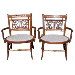 A pair of mahogany Edwardian low-seat armchairs - with satinwood stringing, the lyre carved backs