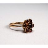 A 9ct yellow gold garnet ring - set in a floral cluster, size P, weight 3.6g.