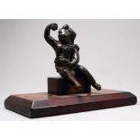 After the antique, a table weight, Bachus with grapes - seated on a wooden plinth, height 11cm.