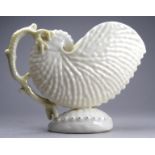 A Belleek vase in the form of a nautilus shell - with coral handle, height 10cm.