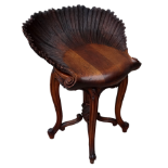 An early 20th century walnut Grotto style piano stool - with a scallop shell carved seat on a