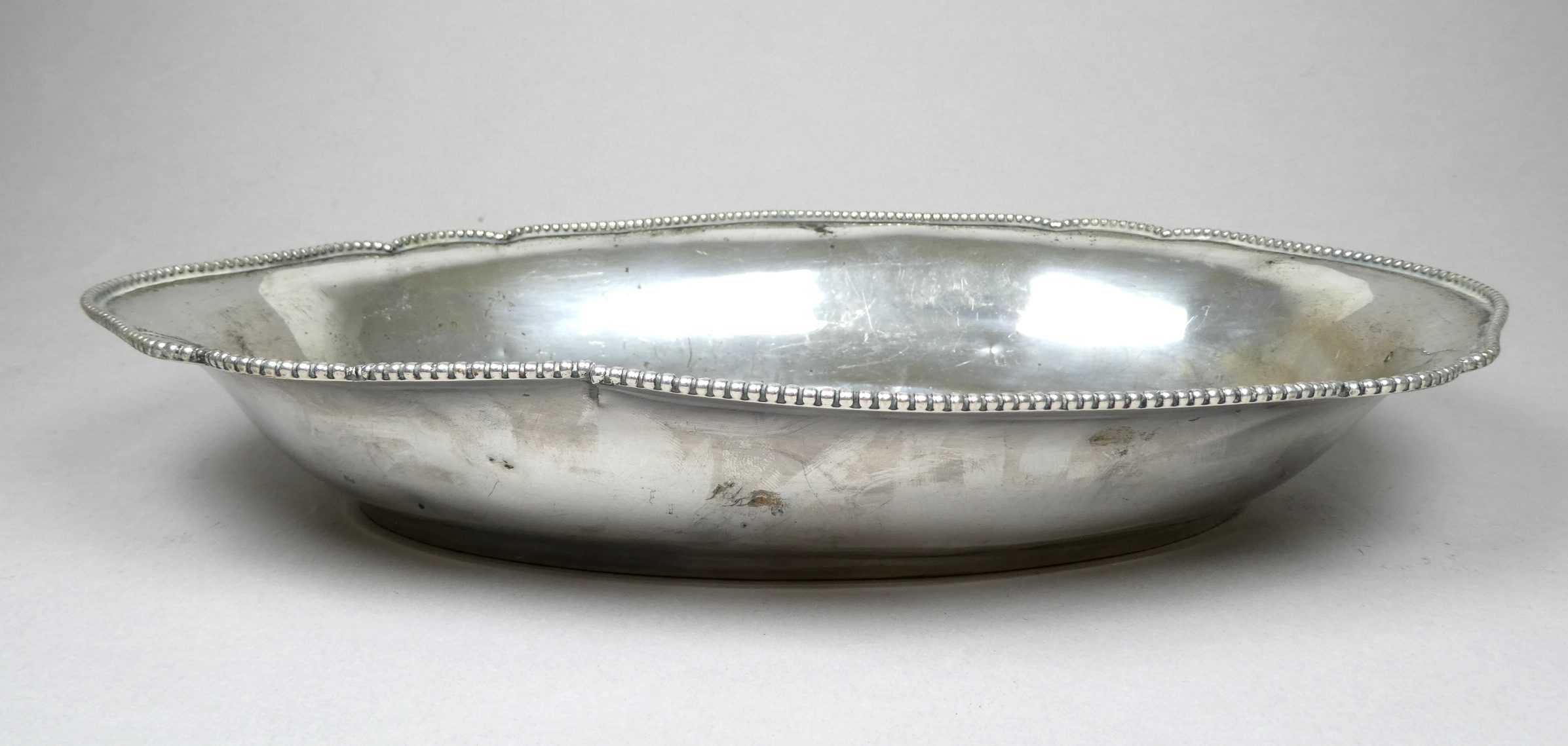 An early 20th century continental white metal dish - stamped 800, of oval form with a shaped bead