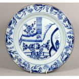 A 19th century Chinese blue and white plate - decorated with an interior scene with a flowers and