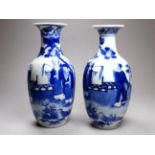 A late 19th century Chinese pair of blue and white decorated vases - depicting scholars in a