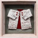 A Norwegian child's coat - white felt with a red lining and stitched decoration with bone toggle