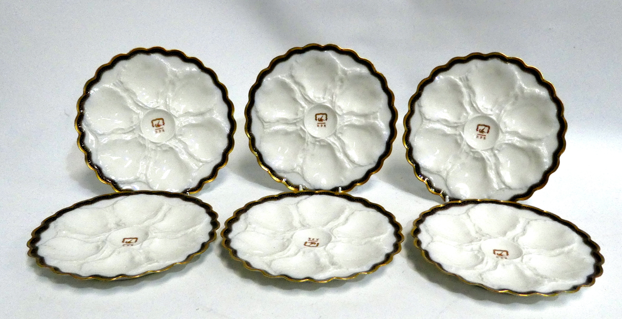 A set of six early 20th century French oyster plates - moulded with a gilt rim and ownership