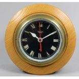 A Smiths Astral bulkhead clock - fitted to a later birch turned case, the black dial set out in