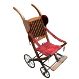An Edwardian American walnut pushchair - a stickback with upholstered seat and arms.