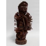 An early 20th century Kongolese Nkisi Nkonde nail power figure - wooden, the knitted cap with cowrie