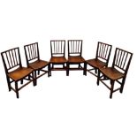 A set of six George III fruitwood dining chairs - with a stick back above a contoured solid seat and