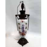 A continental ceramic and brass mounted lamp - now converted to electricity, decorated with a