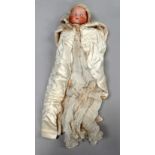An early 20th century Armand Marseille doll - with sleep eyes, dressed in white linen, length 39cm.