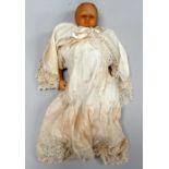 A late 19th century wax head doll - with upholstered body and wax limbs, dressed in a white lace
