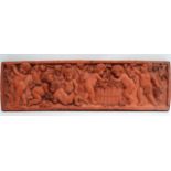 A terracotta plaque - decorated with cherubs indulging in a Bacchanalian feast, 15 x 51.5cm.