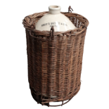A stoneware jar inscribed 'Robert R. Bartlett & Sons Bristol' in a twin handled wicker basket -