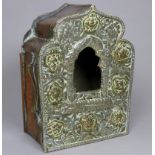 A 19th century Indian white metal and copper shrine - decorated with flowers and foliage about an