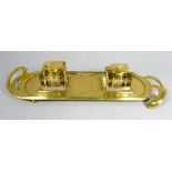 An early 20th century brass standish - in the Arts and Crafts manner, incorporating two inkwells,