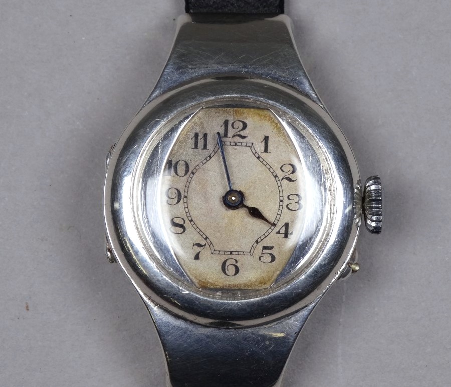 An early 20th century silver cased wristwatch - import mark for London 1913, the silvered dial set
