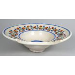 An 18th century faience barber's bowl - of typical form, decorated with flowers and foliage,