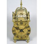 A 17th century style lantern clock - the brass dial set out with Roman numerals, incorporating a
