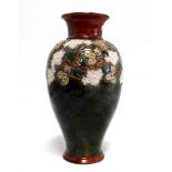 A Lambeth Doulton vase - of baluster form and decorated with trailing flowers on a mottled ground,