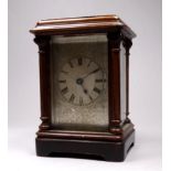 An early 20th century brass carriage timepiece - the wooden case with carved columns, the silvered