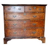 A George II walnut chest of drawers - the quartered veneered top above an arrangement of two short