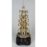 An early 20th century white metal pagoda - raised on a hardwood base, height 18cm.