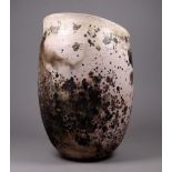 A raku pottery 'birds egg' vase - the pale pink ground with mottled decoration, maximum height 22cm.