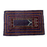 An Afghan prayer rug - the blue ground with a central motif surrounded by multiple borders, 140 x