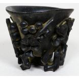 An early 20th century hardwood libation cup - carved with flowers, buds and foliage, height 7cm.