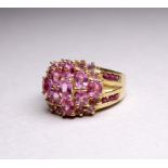 A 9ct yellow gold and pink topaz dress ring - cluster set stone with further to the shanks, ring