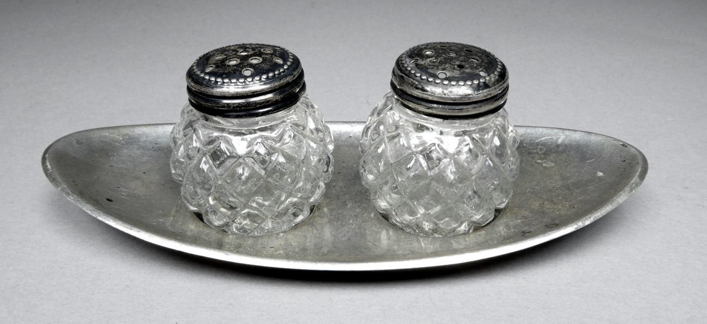 A white metal condiment tray - strike mark to rim, with two cut glass pots, width 12cm.